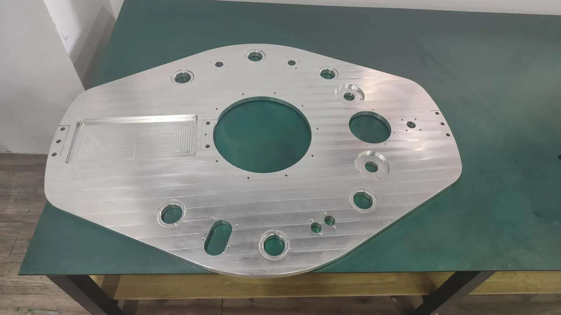 A high-precision large aluminum alloy component freshly processed by CNC machining, showing detailed tool paths and clean surfaces.