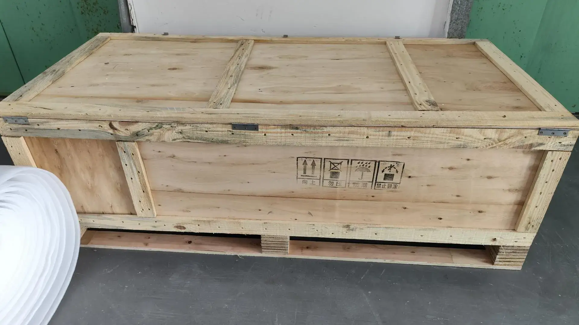 Custom-built wooden crates being prepared for shipping, providing maximum protection for large and delicate machined components during international transit.